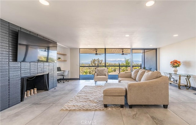 10220 Balmoral Ct, Riverside, CA 92503 - living area with baseboards, a brick fireplace, a wall of windows, a ceiling fan, and recessed lighting