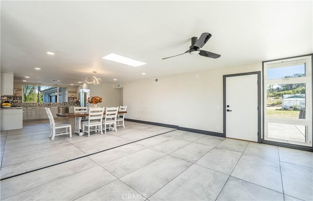 10220 Balmoral Ct, Riverside, CA 92503 - unfurnished dining area featuring ceiling fan, light tile patterned floors, recessed lighting, a skylight, and baseboards