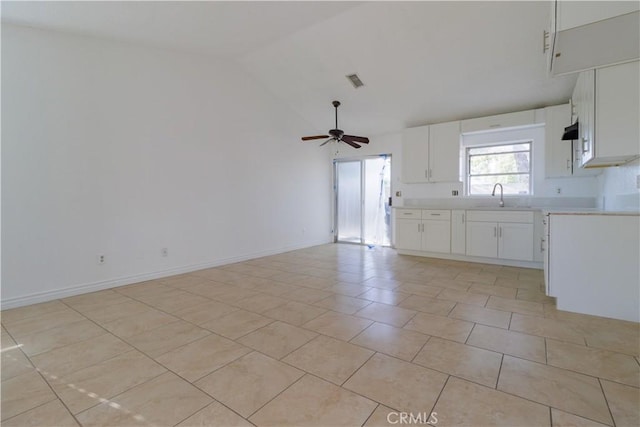 kitchen with light countertops, a sink, a ceiling fan, and open floor plan