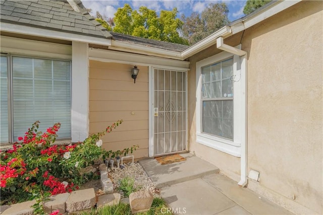 14256 Parkview Dr, Fontana, CA 92337 - property entrance featuring roof with shingles and stucco siding