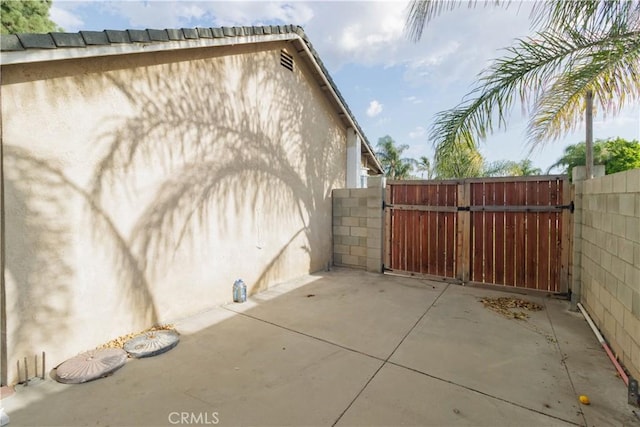 view of home's exterior with a gate, stucco siding, and fence