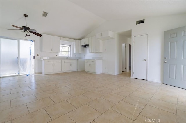 kitchen featuring white cabinets, visible vents, a ceiling fan, lofted ceiling, and a sink