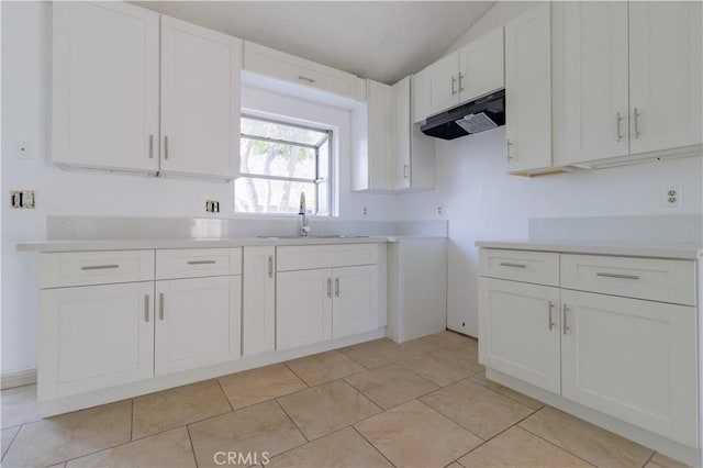 14256 Parkview Dr, Fontana, CA 92337 - kitchen featuring under cabinet range hood, a sink, white cabinetry, light countertops, and light tile patterned floors