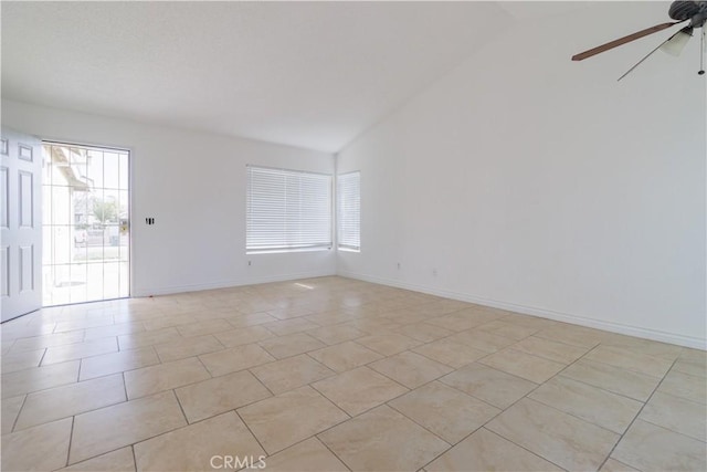 empty room with light tile patterned floors, baseboards, vaulted ceiling, and ceiling fan
