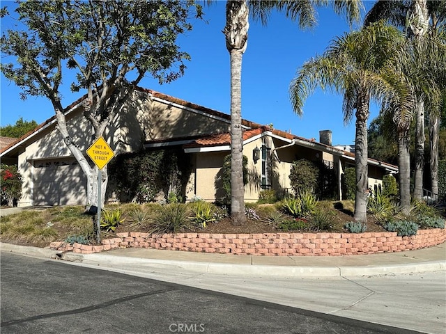 5219 Moya, Laguna Woods, CA 92637 - view of front of home featuring stucco siding, a tiled roof, and an attached garage
