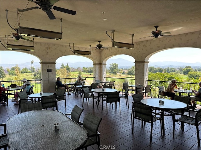 view of patio / terrace with a mountain view, outdoor dining space, and ceiling fan
