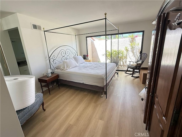 bedroom featuring light wood finished floors and visible vents
