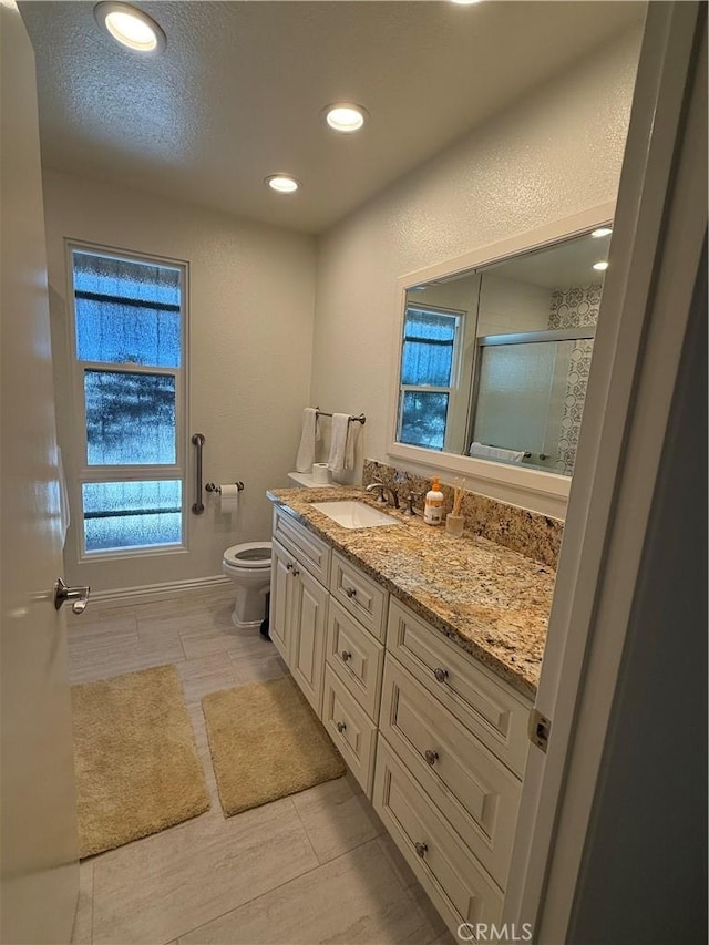 bathroom with recessed lighting, a shower stall, toilet, and vanity