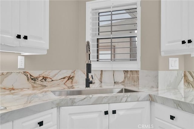 57 Plaza Brisas, San Juan Capistrano, CA 92675 - kitchen with light stone countertops, white cabinetry, a sink, and backsplash