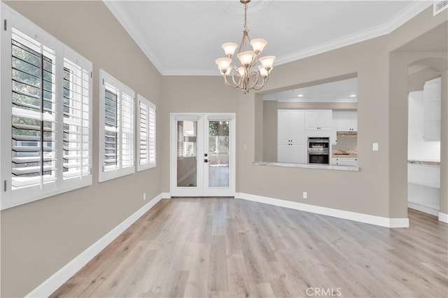 57 Plaza Brisas, San Juan Capistrano, CA 92675 - unfurnished dining area with french doors, ornamental molding, light wood-style flooring, and an inviting chandelier