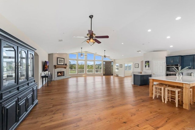 20191 Deerben Rd, Ramona, CA 92065 - living room featuring a ceiling fan, lofted ceiling, a lit fireplace, light wood-style floors, and recessed lighting