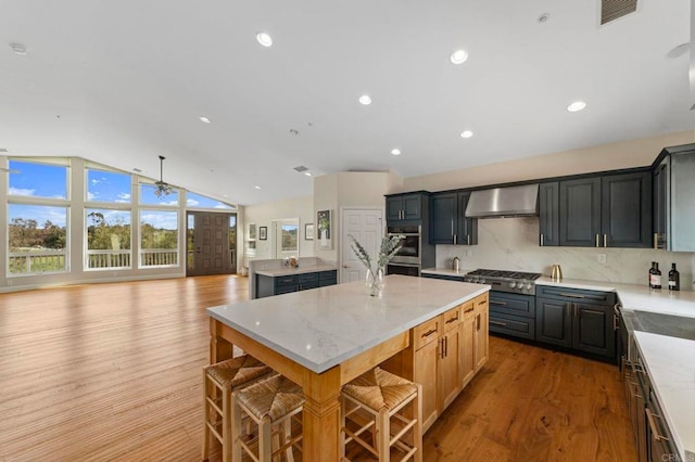 20191 Deerben Rd, Ramona, CA 92065 - kitchen with wall chimney exhaust hood, a center island, appliances with stainless steel finishes, lofted ceiling, and wood finished floors