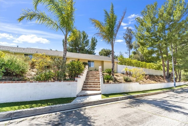 9056 Oswego St, Sunland, CA 91040 - view of front facade with fence, stucco siding, an attached garage, and stairway