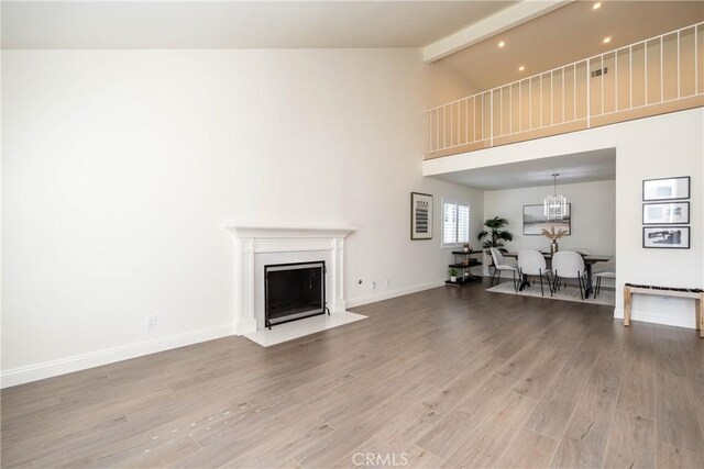 24461 Peacock St, Lake Forest, CA 92630 - living area with beamed ceiling, high vaulted ceiling, light wood-style floors, a fireplace with flush hearth, and baseboards