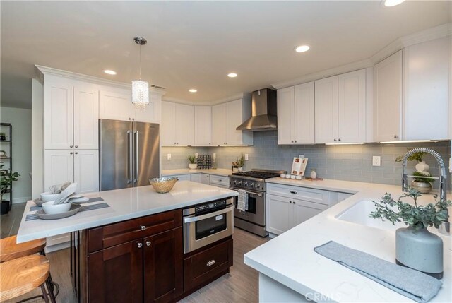 24461 Peacock St, Lake Forest, CA 92630 - kitchen with high quality appliances, wall chimney exhaust hood, light countertops, a sink, and wood finished floors