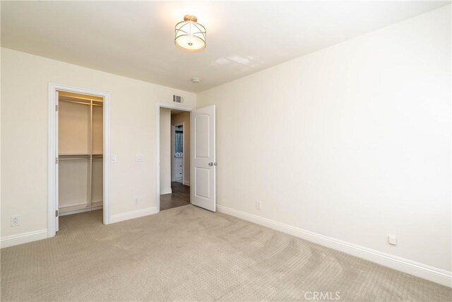 24461 Peacock St, Lake Forest, CA 92630 - unfurnished bedroom featuring light carpet, baseboards, a walk in closet, and a closet