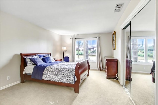 bedroom with light carpet, visible vents, and multiple windows
