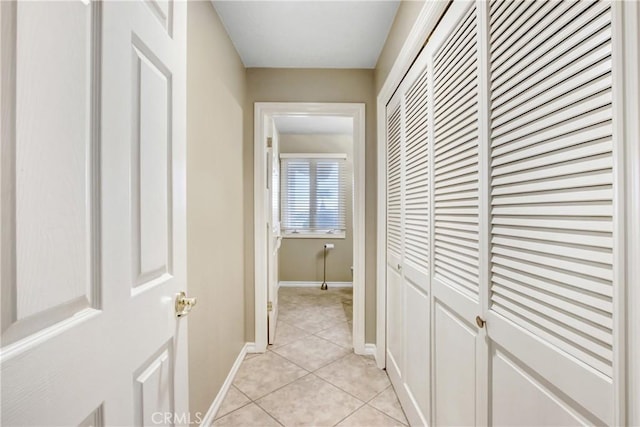 hallway with light tile patterned floors and baseboards