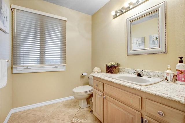 bathroom featuring tile patterned floors, vanity, baseboards, and toilet
