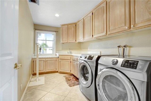 washroom with separate washer and dryer, baseboards, light tile patterned floors, cabinet space, and a sink