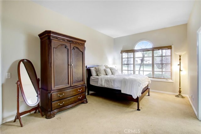 bedroom featuring baseboards and light carpet