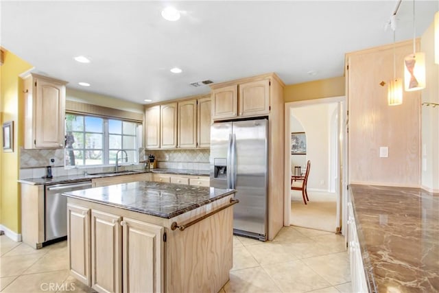 kitchen with dark stone countertops, visible vents, light brown cabinets, and appliances with stainless steel finishes