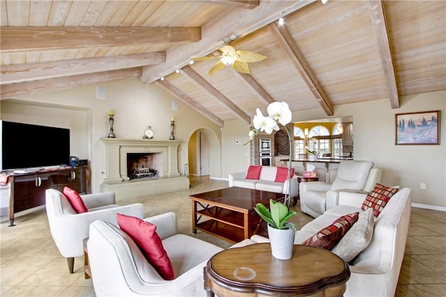 living area with vaulted ceiling with beams, tile patterned floors, baseboards, and wooden ceiling