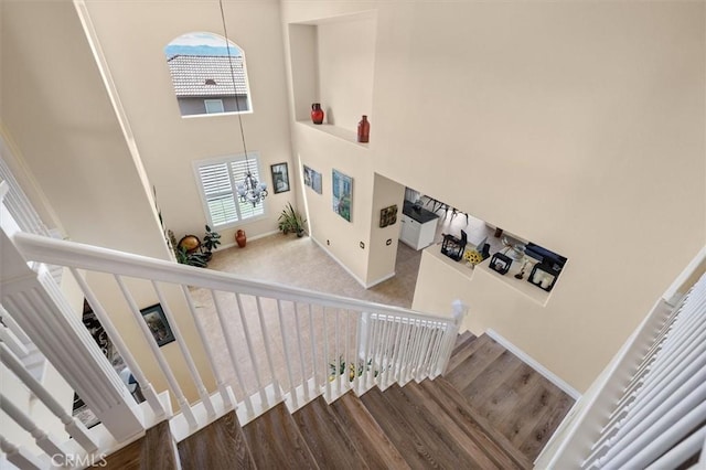 14209 Wrangell Ln, Canyon Country, CA 91387 - stairs with a towering ceiling, baseboards, wood finished floors, and a chandelier