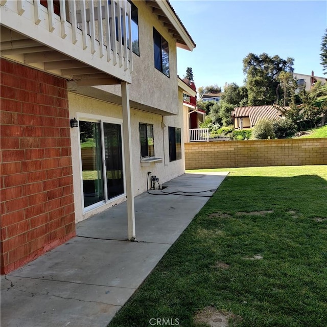 view of yard with a patio, fence, and a balcony