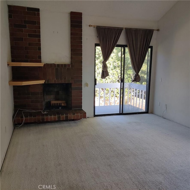 unfurnished living room featuring carpet and a brick fireplace