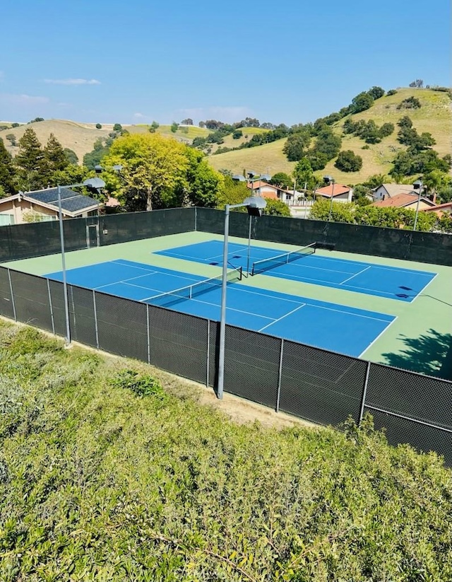 view of tennis court featuring fence