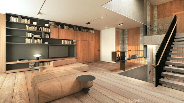 living area with stairs, a fireplace, and wood finished floors