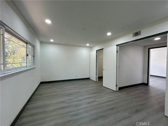 empty room featuring crown molding, baseboards, and recessed lighting