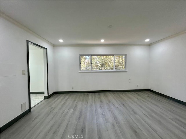 empty room with recessed lighting, baseboards, ornamental molding, and wood finished floors