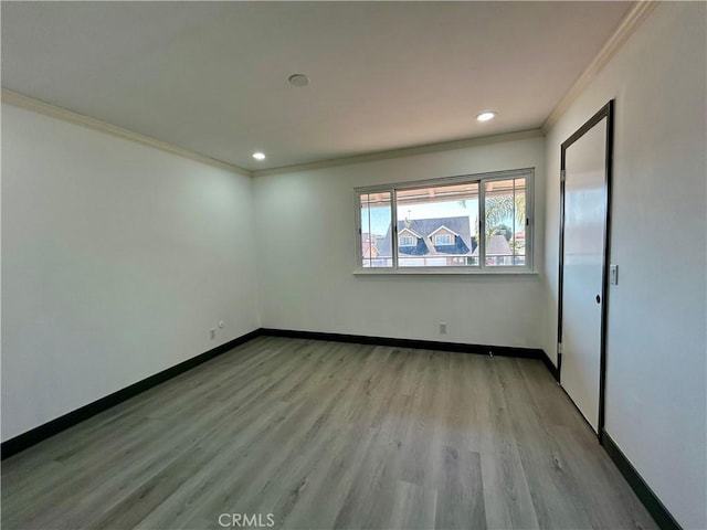 interior space featuring recessed lighting, light wood finished floors, baseboards, and crown molding