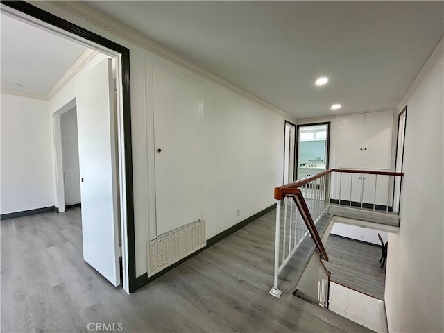 hallway with crown molding, recessed lighting, wood finished floors, an upstairs landing, and baseboards