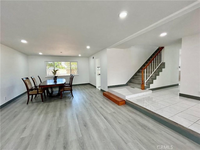 dining room featuring recessed lighting, light wood-style floors, baseboards, and stairs