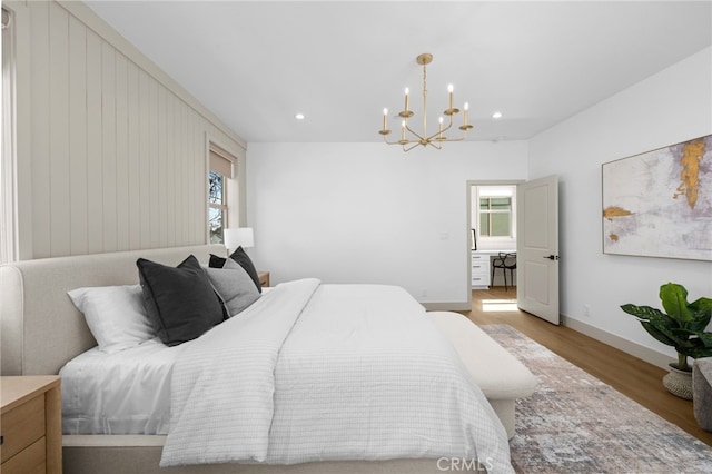bedroom with wood finished floors, a notable chandelier, multiple windows, and recessed lighting