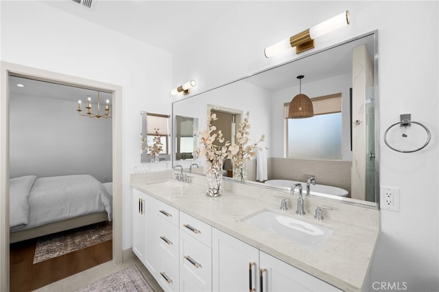 bathroom featuring a freestanding bath, double vanity, ensuite bathroom, and a sink