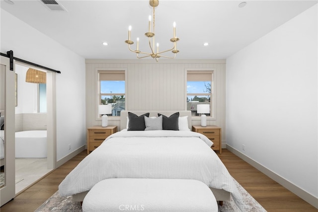 bedroom featuring visible vents, multiple windows, an inviting chandelier, and wood finished floors