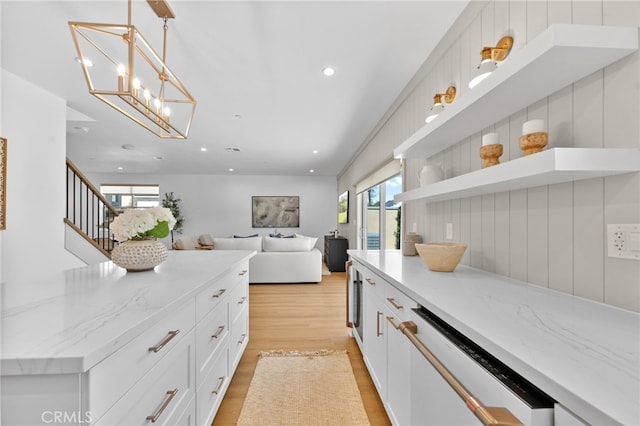 kitchen with light stone countertops, light wood-type flooring, white cabinets, recessed lighting, and dishwasher