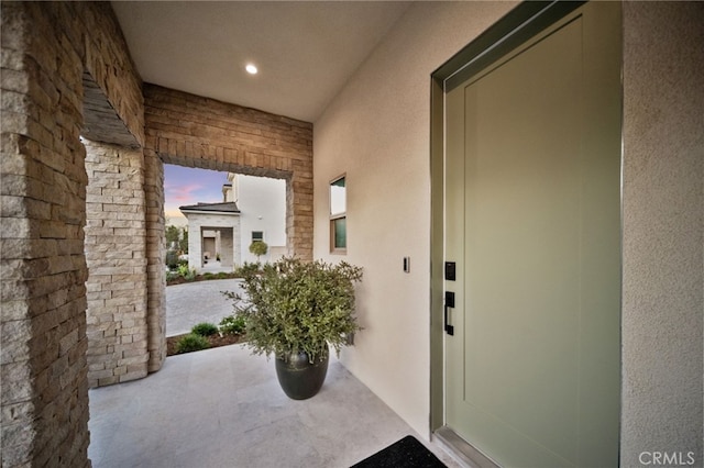 entrance to property with stucco siding and stone siding