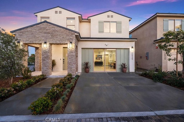 view of front of home featuring stucco siding and stone siding