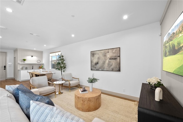 living room with visible vents, light wood-style flooring, recessed lighting, and baseboards