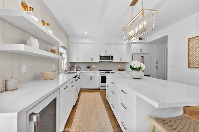 kitchen featuring range, open shelves, dishwasher, a sink, and high end fridge