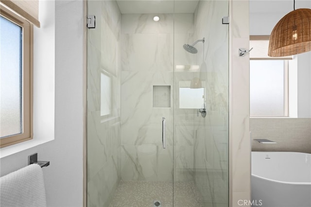 bathroom featuring a marble finish shower and plenty of natural light