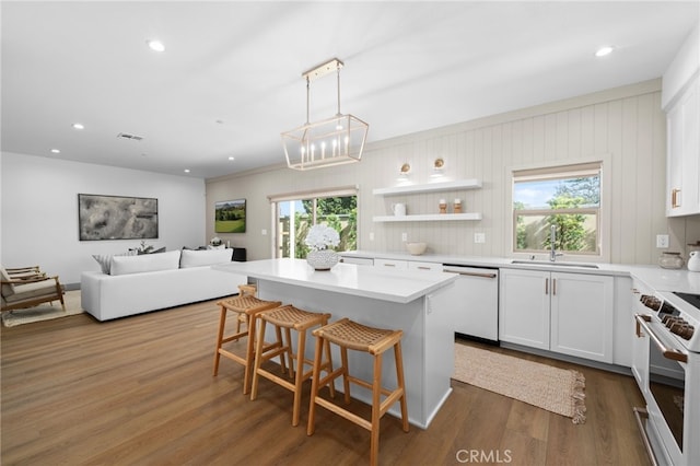 kitchen featuring a sink, range, white dishwasher, and dark wood-style floors