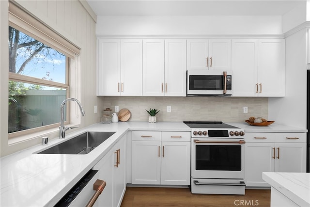 kitchen with white cabinets, tasteful backsplash, white appliances, and a sink