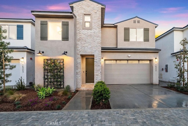 16227 Orizaba Ave, Paramount, CA 90723 - view of front facade featuring a garage, driveway, stucco siding, and stone siding