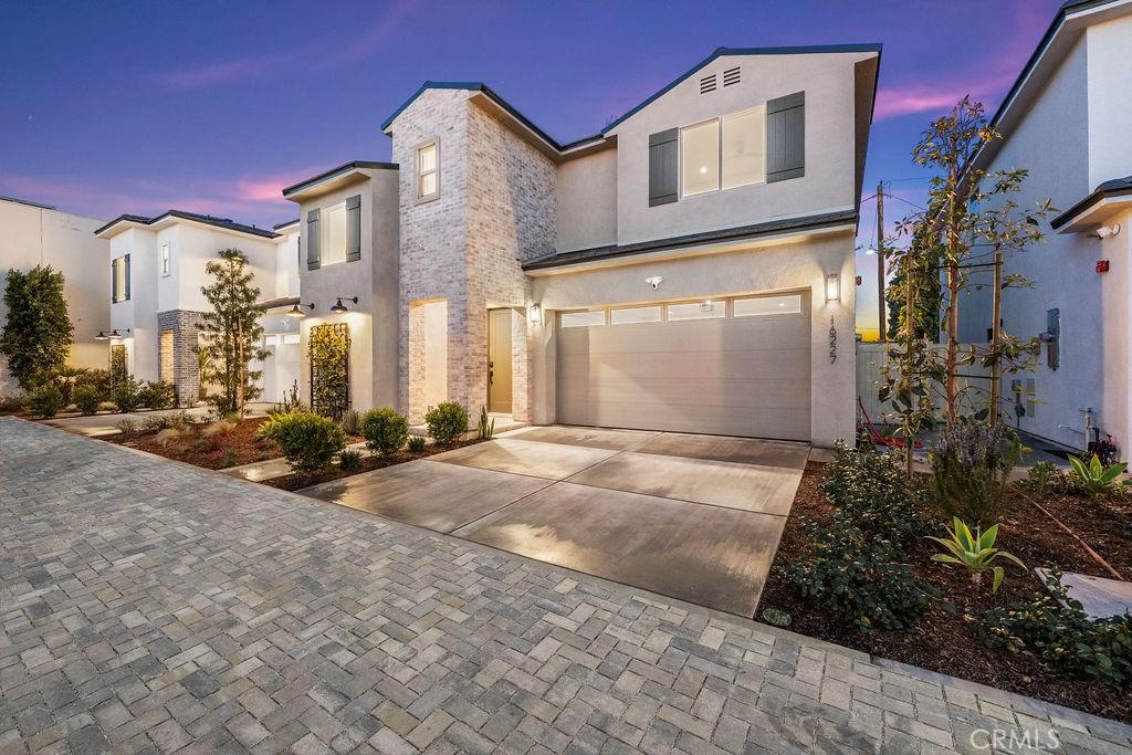16227 Orizaba Ave, Paramount, CA 90723 - view of front of property with a garage, driveway, and stucco siding